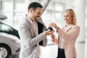 Happy customer just bought a car at car dealership